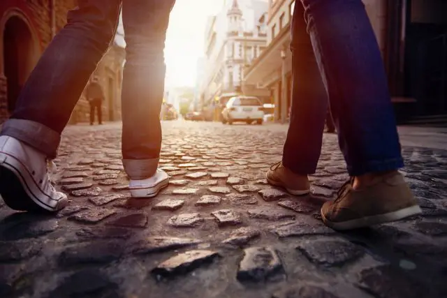 tourist couple walking on cobblestone street vacation in europe on holiday break