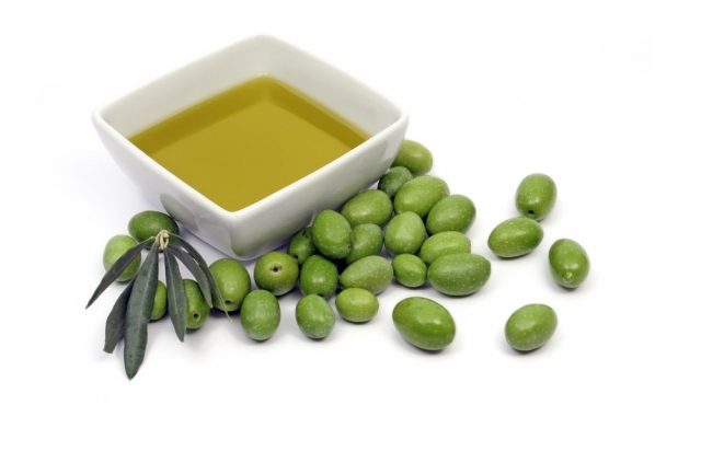 Extra virgin olive oil with fresh green olives