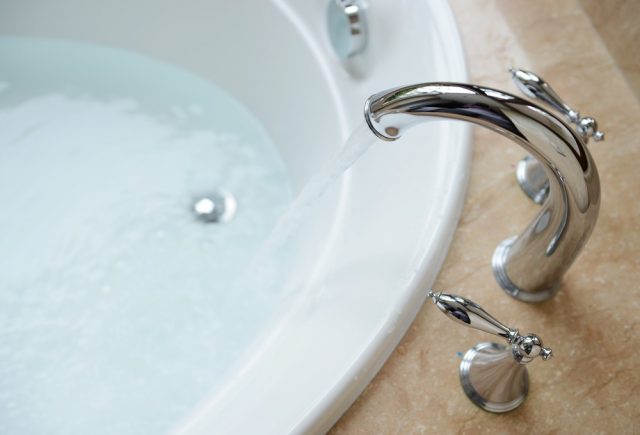 Luxury bath tub and faucet with water