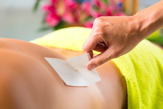 Man in Spa getting back waxed or sugared for hair removal