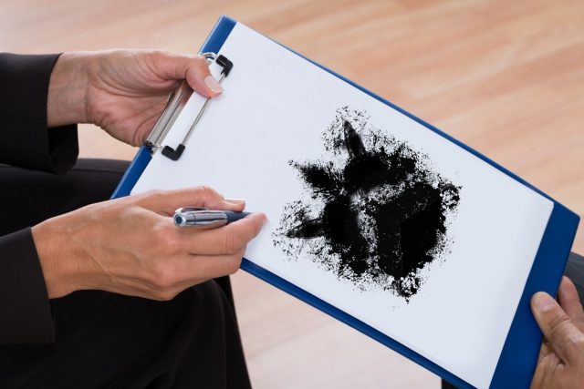 A Psychologist Showing Rorschach Inkblot On Clipboard To Patient