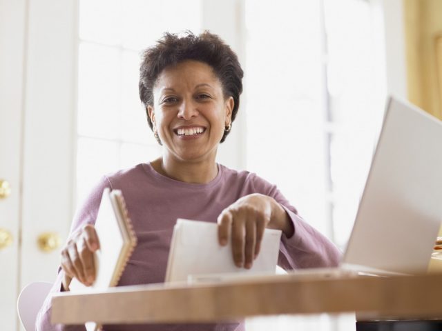 Middle-aged woman smiling for the camera at her desk