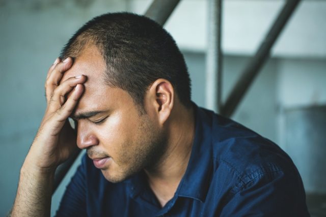 Depressed man sitting head in hands