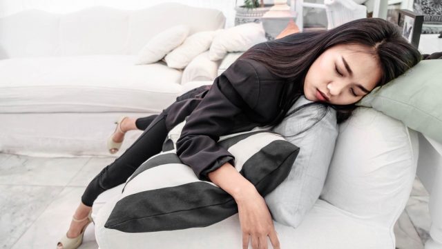 Asian business girl lying on a white sofa Fatigue, fatigue, hard work