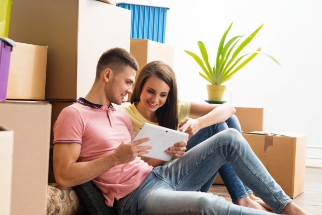 Young couple moving in a new home. Man and woman with boxes