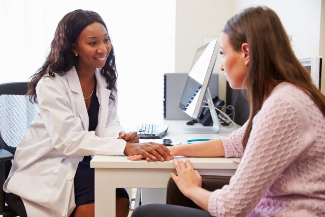 Female Doctor Treating Patient Suffering With ovary pain