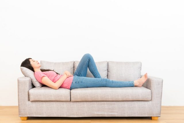 young woman lying on couch and resting sleeping