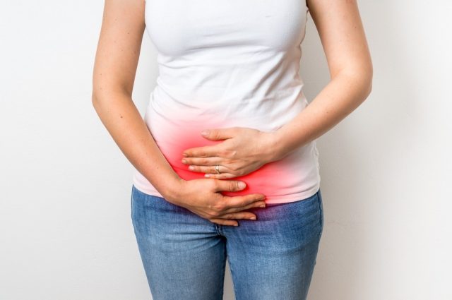 Woman with pain is holding her aching belly